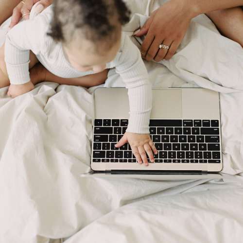 Toddler typing on laptop