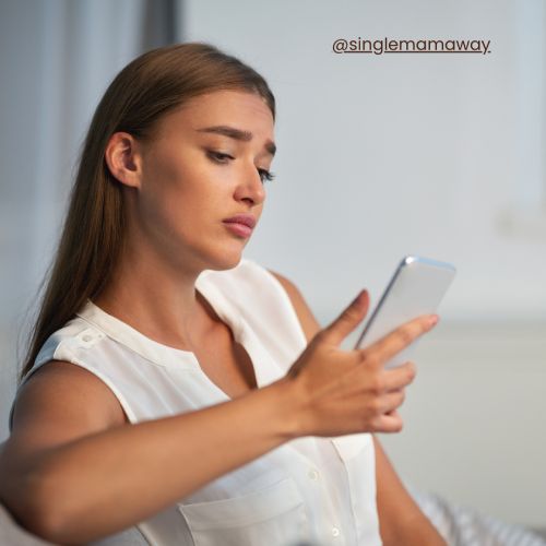 Forlorn woman looking saddly at her phone