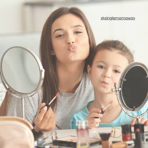 Mum and young daughter applying make up together