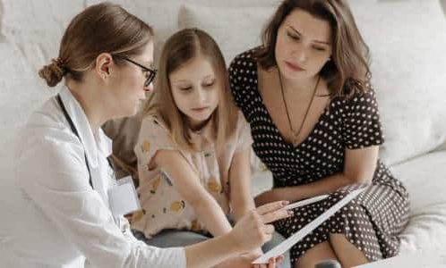 Mother and daughter talking to female doctor